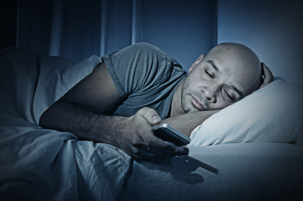 Young Cell Phone Addict Man Sleeping At Night In Bed While Using 